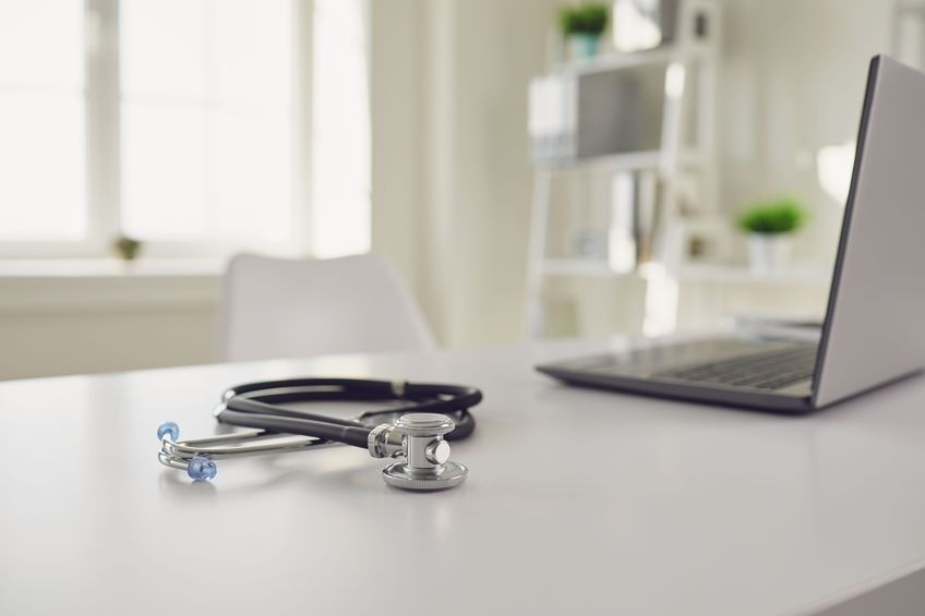 Doctor online. A stethoscope is on a white table with a laptop in blur at the hospital office. The concept of medical consultation for patients call to medical services. Consultation diagnosis remote sensing survey analysis of prescription medical insurance for sick people patients.